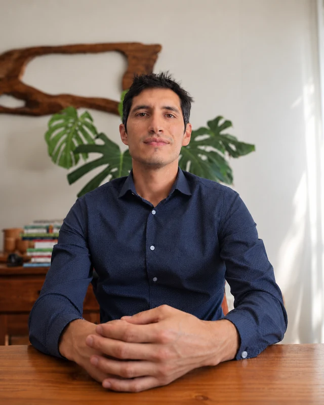 Nico Cabib, psicólogo clínico, sentado con camisa azul.